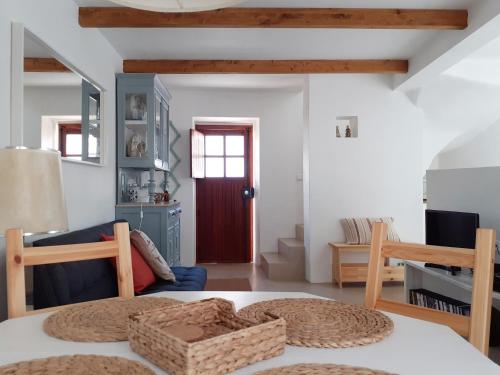 a living room with a table and a red door at Casa da Bica d'Água in Óbidos