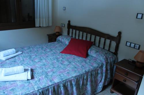 a bedroom with a bed with a red pillow on it at Apartaments Vilaró in Llorts