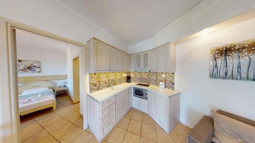 a kitchen with white cabinets and a sink at Aneria Suites in Episkopí- Rethimno