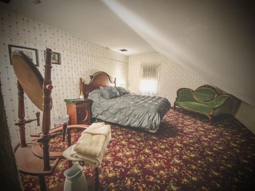 a bedroom with a bed and a mirror and a chair at Lizzie Borden House in Fall River