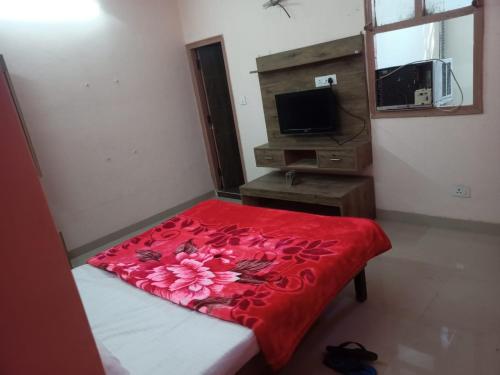 um quarto com uma cama com um cobertor vermelho em HOTEL THE DIAMOND LEAF em Chandīgarh