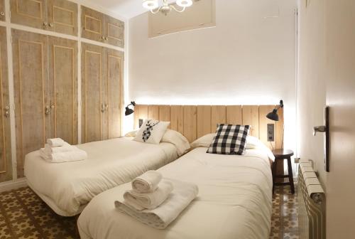 Dos camas en una habitación con toallas. en Casa Lola - Terraza panorámica en el centro del pueblo, en Sant Joan de les Abadesses