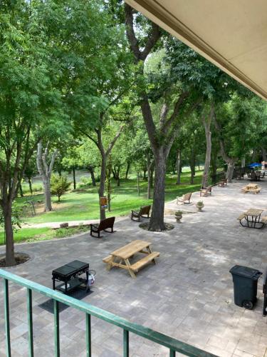 a park with benches and picnic tables and trees at Horseshoe Riverside Lodge in Canyon Lake