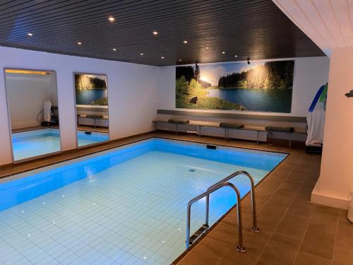 Hotel Haus am Hochwald في بوكسفيس هاننكلي: مسبح كبير في غرفة الفندق مع مسبح كبير