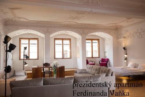 a living room with couches and a bed and windows at Besidka in Slavonice