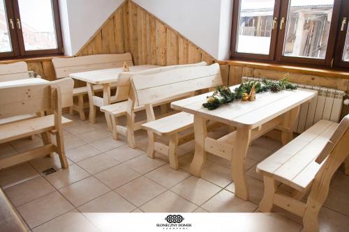 un restaurante con mesas de madera, bancos y ventanas en Słoneczny Domek, en Zakopane