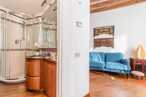 uma casa de banho com um sofá azul e um chuveiro em 7 WINDOWS ON VENICE em Veneza