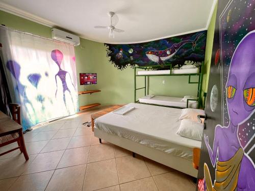 a bedroom with a bed and a painting on the wall at Green Haven Hostel in Ubatuba