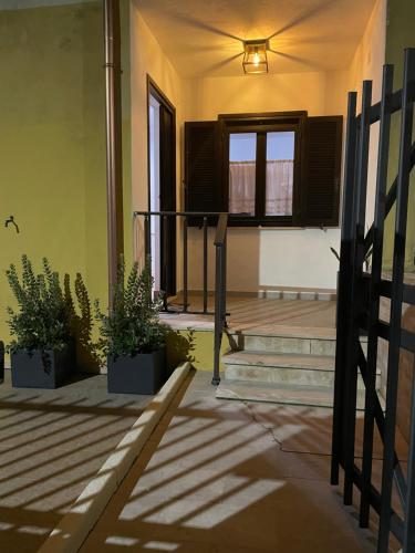 a porch with stairs and potted plants in a building at Appartamenti ucuppu in Carloforte