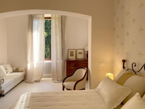 a bedroom with a bed and a couch and a window at Villa Lina in Tremezzo