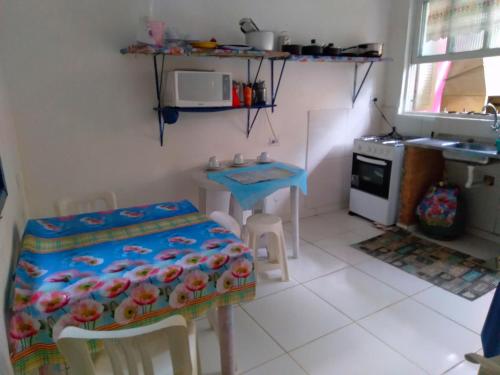 a small kitchen with a table and a table and chairs at SUITES E CHALES PRIVADOS Rock's&Rose's home in Camburi