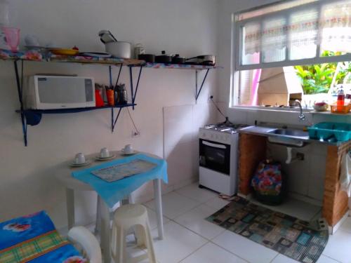 a small kitchen with a sink and a stove at SUITES E CHALES PRIVADOS Rock's&Rose's home in Camburi