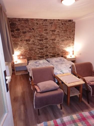 a bedroom with a bed and a table and a chair at Privát Zvonček in Terchová