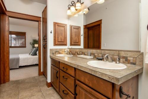 baño con 2 lavabos y espejo grande en Modern Riverstone Condo with Grand Deck - Steps to Shops, Restaurants & Trail en Coeur d'Alene