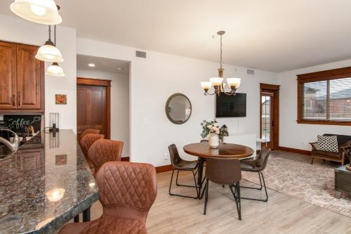 a kitchen and living room with a table and chairs at Modern Riverstone Condo with Grand Deck - Steps to Shops, Restaurants, Trails and River in Coeur d'Alene