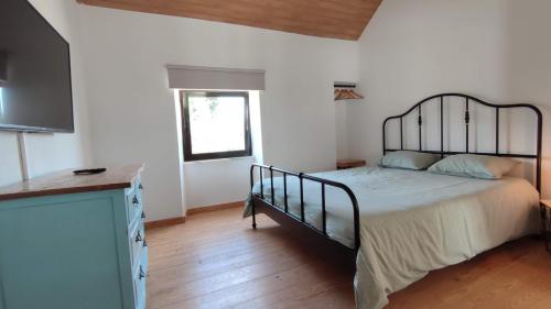 a bedroom with a bed and a television in it at Pomar das Oliveiras - Private Swimming pool - Free EV Chrg - Pet Friendly in Carvalhal Cimeiro