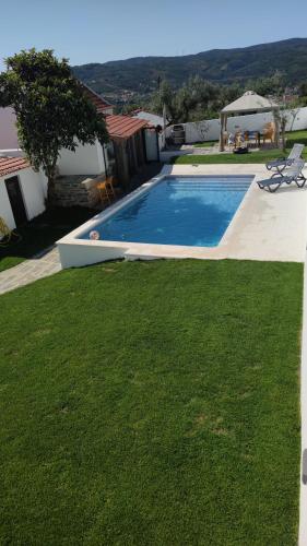 a swimming pool in a yard with green grass at Pomar das Oliveiras - Private Swimming pool - Free EV Chrg - Pet Friendly in Carvalhal Cimeiro