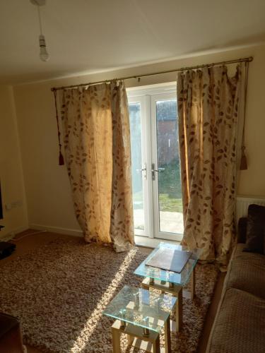 a living room with a couch and a window at Immaculate 3 bedroom property. in Nottingham