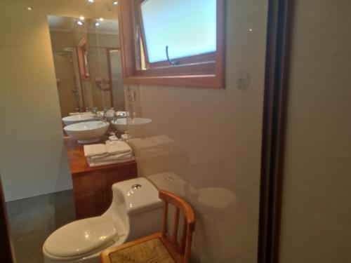 ein Badezimmer mit Toilette und Waschbecken in der Unterkunft Casa verano piscina Villarrica in Villarrica