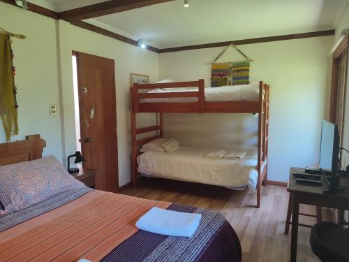 ein Schlafzimmer mit zwei Etagenbetten und einem Schreibtisch in der Unterkunft Casa verano piscina Villarrica in Villarrica