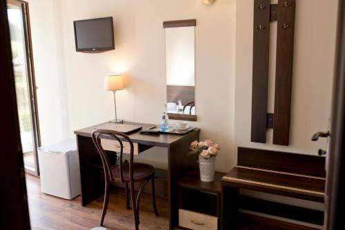 a room with a desk with a chair and a mirror at Pensjonat pod Samowarem in Tylicz