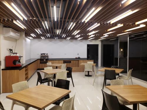 Un comedor con mesas y sillas de madera. en Tuareg Suite Deluxe, en Santa Cruz de la Sierra