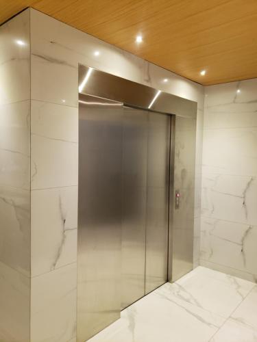 ascensor en una habitación con paredes de mármol blanco en Tuareg Suite Deluxe, en Santa Cruz de la Sierra