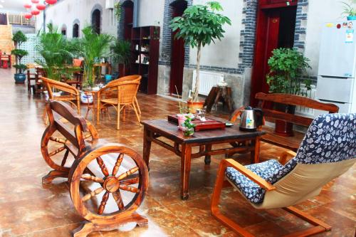 a room with chairs and a table and a rocking chair at Jinan Mountain and Sea Culture Hotel in Jinan