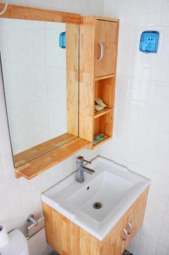 a bathroom with a sink and a mirror at Jinan Mountain and Sea Culture Hotel in Jinan