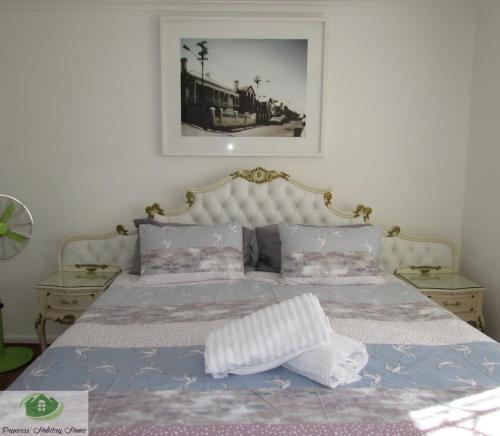 a bedroom with a bed and a picture on the wall at Princess Holiday Home in Cape Town