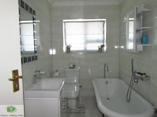 a white bathroom with a sink and a toilet and a tub at Princess Holiday Home in Cape Town