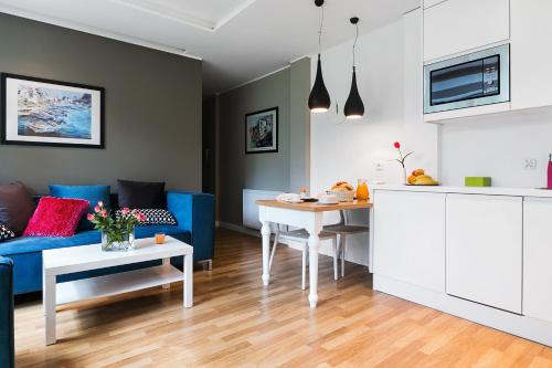 a living room with a blue couch and a table at Costa Apartments in Sopot