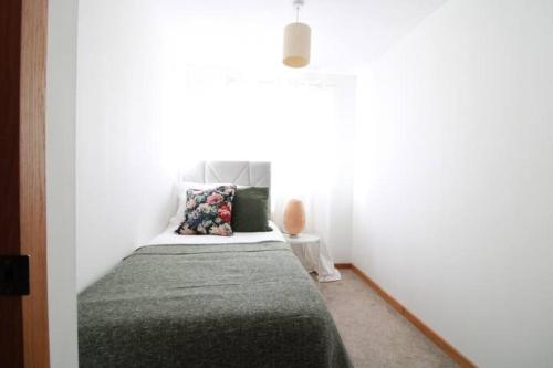 a bedroom with a bed in a white room at Cheerful Two-Bedroom Residential Home in Oxford