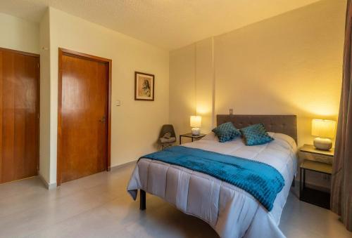 a bedroom with a large bed with a blue blanket at Mexico Historic Center Modern Apartment in Mexico City