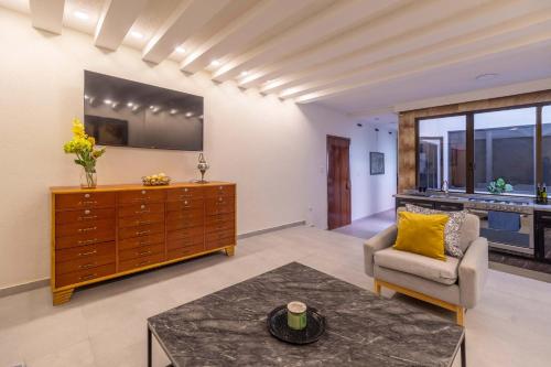 a living room with a dresser and a chair at Mexico Historic Center Modern Apartment in Mexico City