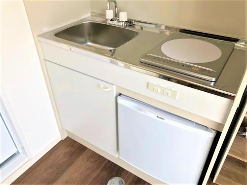 a kitchen with a sink and a stove and a dishwasher at Hotel PEACE PARK Tokaichi - Vacation STAY 95327v in Hiroshima