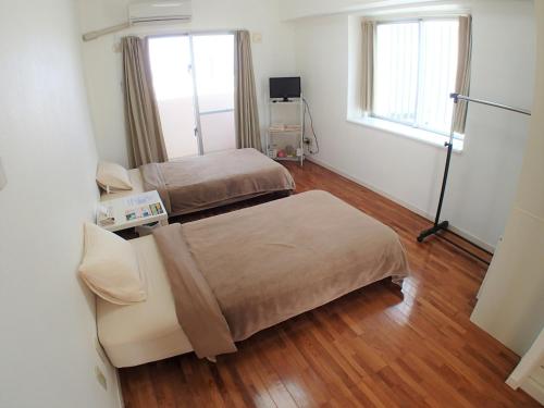 um quarto de hospital com duas camas e uma janela em Lagoon Palace - Vacation STAY 95305v em Nogunukaniku