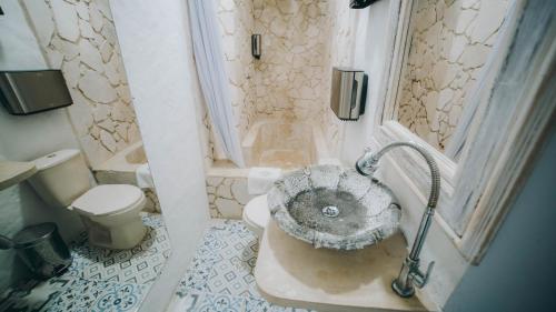 uma casa de banho com um lavatório e um chuveiro com um WC. em Ángel De Santa Fe em Santa Fe de Antioquia