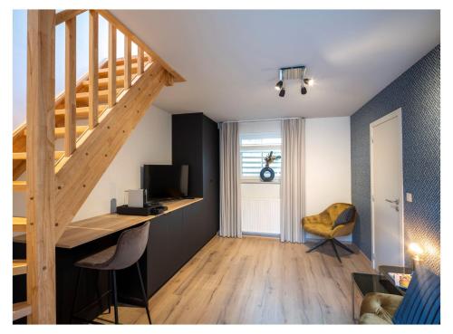 a room with a staircase and a desk with a television at B&B De Floreffe in Overpelt