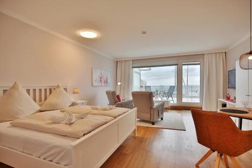 a bedroom with a large bed and a living room at Haus Seebrücke Haus Seebrücke Appartement 02 in Niendorf
