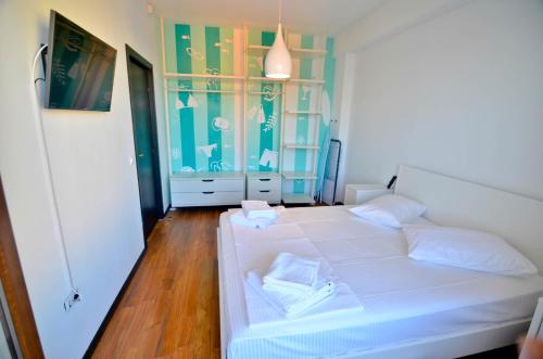 a bedroom with a white bed and a glass cabinet at Summerland Happy Blue Apartments in Mamaia