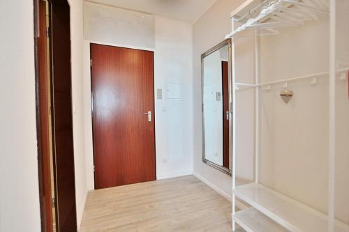 a hallway with a wooden door and a closet at Haus Seebrücke Haus Seebrücke Appartement 10 in Niendorf