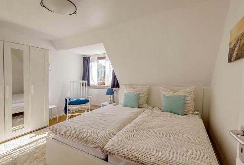 1 dormitorio con 1 cama grande con almohadas azules en Haus Lubecca Ferienhaus Lubecca Appartement 01, en Timmendorfer Strand