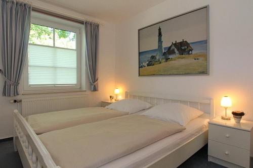 een slaapkamer met 2 bedden en een raam bij Am Elchgrund, im Brook 9 Am Elchgrund Im Brook 9 Appartement 01 in Timmendorfer Strand