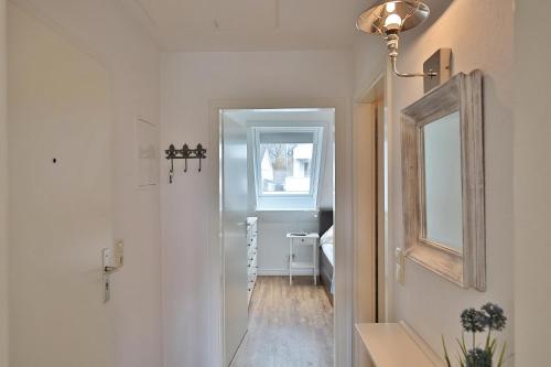 a hallway with a mirror and a bedroom at Im Brook 36-38 Am Elchgrund Appartement 12 in Timmendorfer Strand