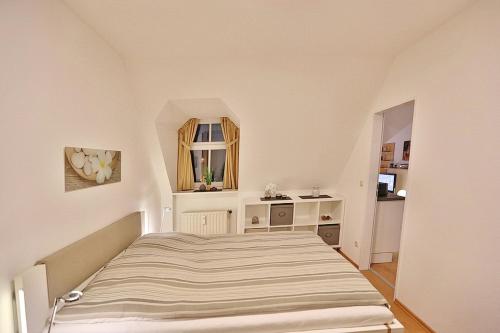Dormitorio pequeño con cama y espejo en Am Rosenhain 12 Am Rosenhain 12 Appartement 4, en Timmendorfer Strand