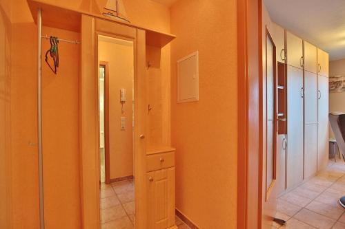 een kamer met oranje muren en een hal met een kast bij Domizil Strandburg Domizil Strandburg Appartement 08 in Timmendorfer Strand