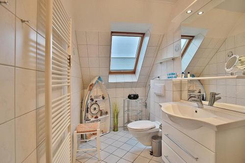 La salle de bains est pourvue d'un lavabo, de toilettes et d'une fenêtre. dans l'établissement Domizil Strandburg Domizil Strandburg Appartement 26 Sonneneck, à Timmendorfer Strand