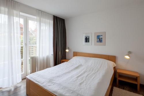ein Schlafzimmer mit einem Bett und einem großen Fenster in der Unterkunft Am Rosenhain 6 Am Rosenhain 6 Appartement 1 in Timmendorfer Strand