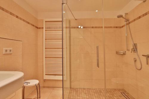 La salle de bains est pourvue d'une douche avec une porte en verre. dans l'établissement Villa Mér Baltique Villa Mér Baltique Appartement 20, à Timmendorfer Strand